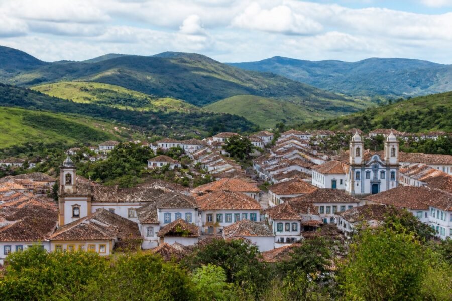 Vista panorâmica da cidade histórica de Serro, cercada pelas montanhas verdes de Minas Gerais.